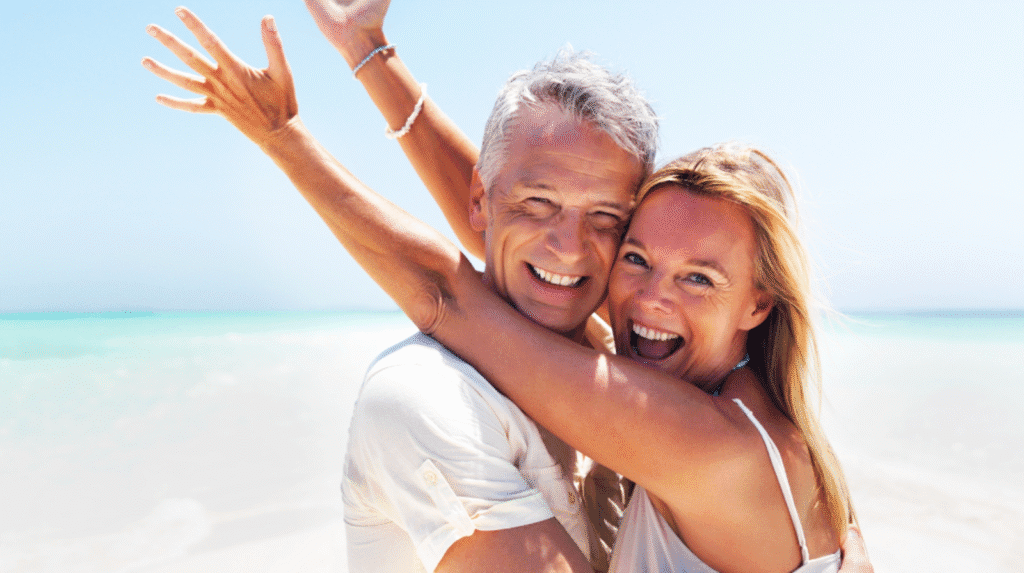 Glückliches Paar um die 50 am Strand – voller Energie und Lebensfreude