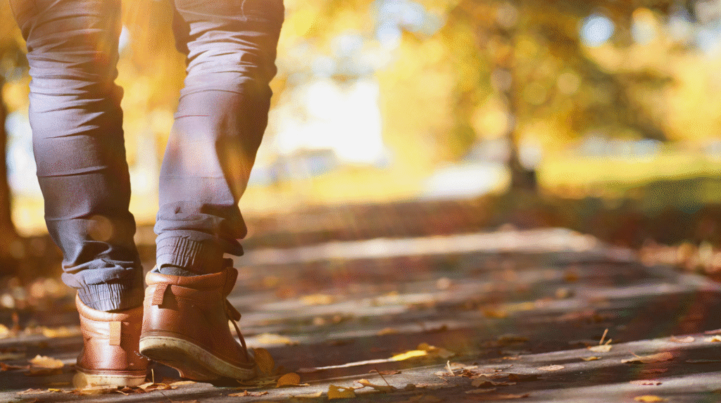 Person geht auf einem herbstlichen Weg spazieren, Symbol für Alltagsbewegung und moderates Kaloriendefizit